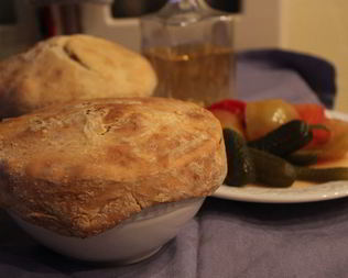 Пельмени в соусе из белых грибов под хлебной шапкой